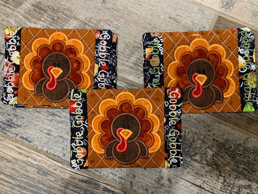 Decorative coasters with turkey designs on a wooden surface